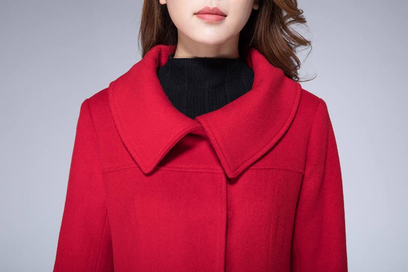 May include: A red wool coat with a large, wide collar. The coat has a single button closure at the front.