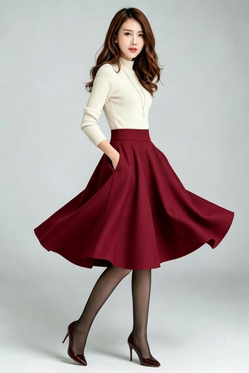 May include: A high-waisted, knee-length burgundy skirt with a flared, A-line silhouette and side pockets, paired with a cream-colored, long-sleeved mock neck top, sheer black tights, and dark burgundy high-heeled pumps.