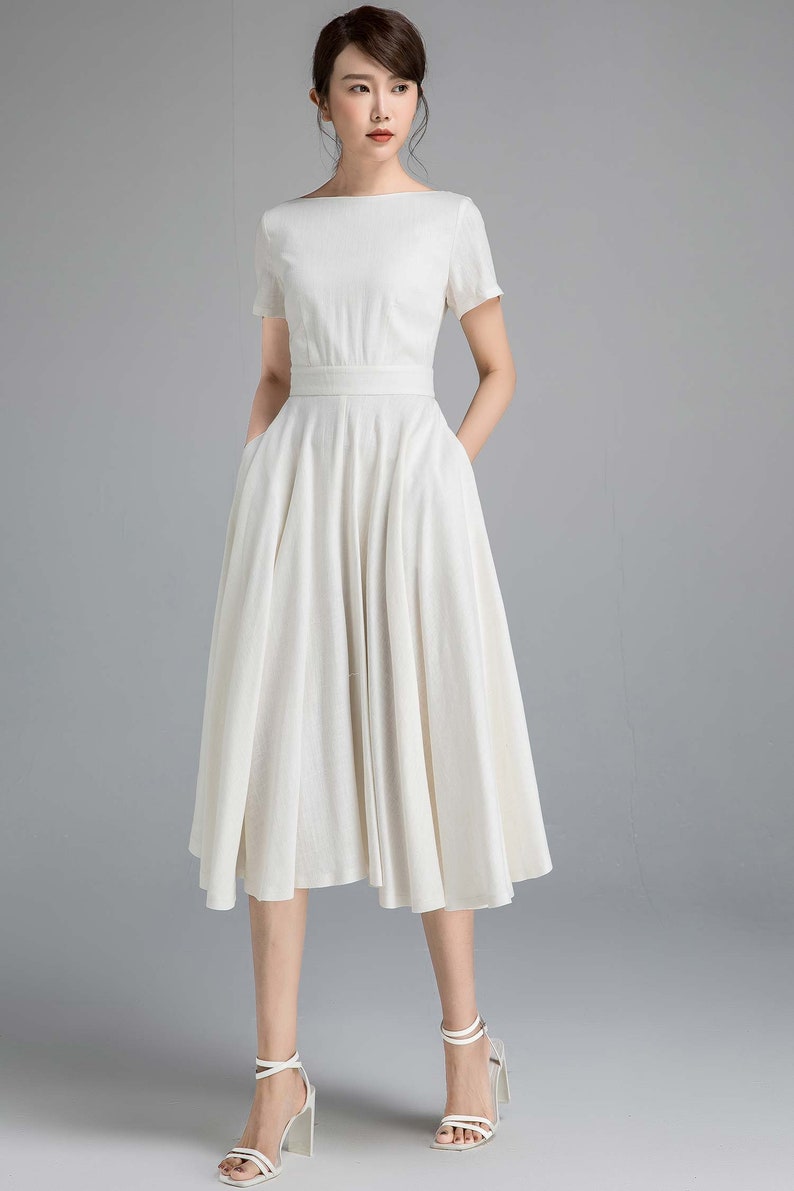 a white linen midi dress with short sleeves