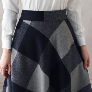 May include: A black and gray plaid skirt with a high waist and a flared silhouette.