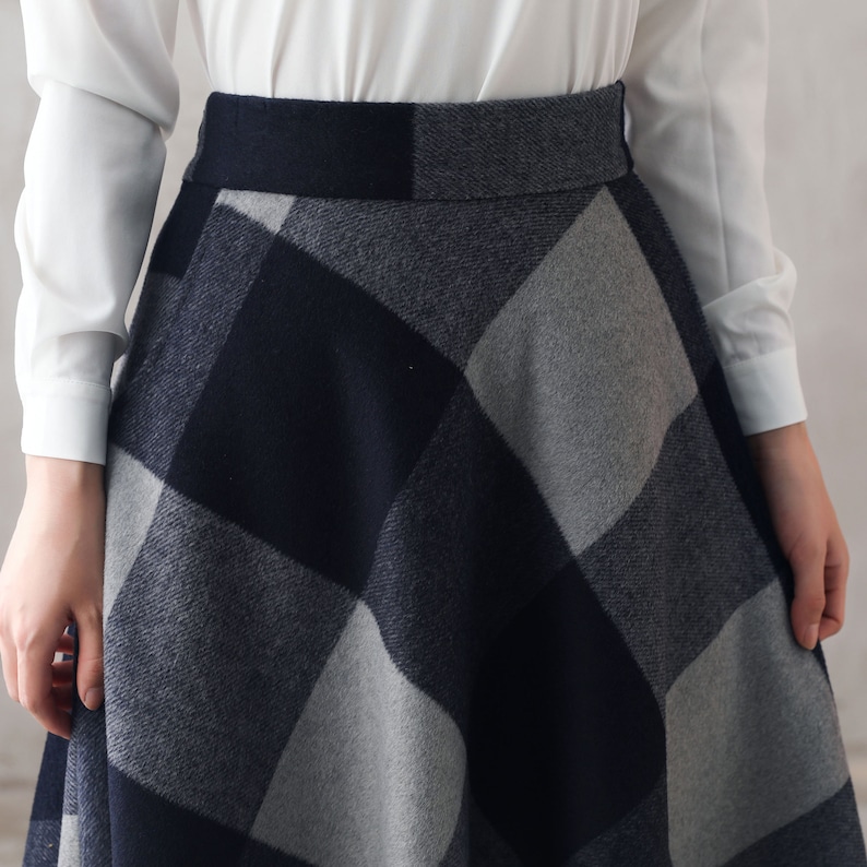 May include: A black and gray plaid skirt with a high waist and a flared silhouette.