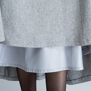 Puede incluir: Una falda gris con una falda interior gris claro. La falda est&aacute; hecha de una tela suave y texturizada.