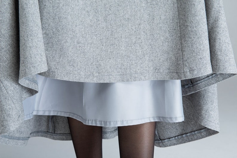 Puede incluir: Una falda gris con una falda interior gris claro. La falda est&aacute; hecha de una tela suave y texturizada.