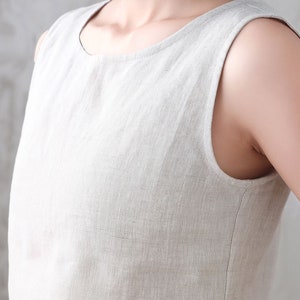 Pu&ograve; includere: Un abito in lino senza maniche di colore beige chiaro. L'abito ha una scollatura rotonda e una vestibilit&agrave; rilassata.
