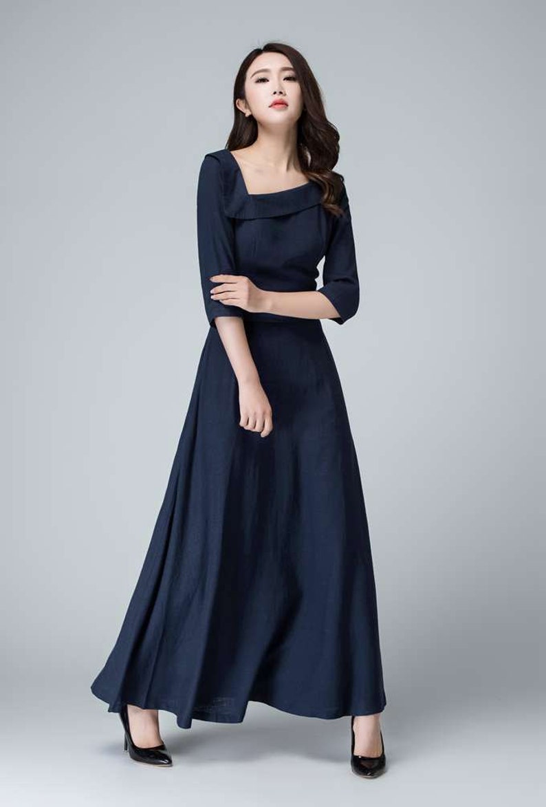 May include: A navy blue maxi dress with a square neckline and three-quarter sleeves. The dress has a fitted bodice and a flowing skirt.