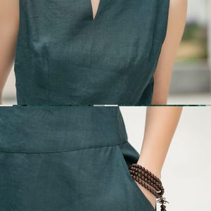 Peut inclure: Une robe en lin sans manches, de couleur vert fonc&eacute;, avec un d&eacute;collet&eacute; en V et une silhouette simple et fluide. La robe a une poche sur le c&ocirc;t&eacute; et une forme l&eacute;g&egrave;rement trap&egrave;ze.