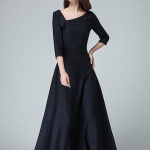 May include: A black maxi dress with a square neckline and a ruffled detail on the shoulder. The dress has a fitted bodice and a flowing skirt.