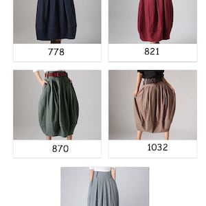 Op de afbeelding: Vijf verschillende kleurvariaties van een rok met een brede tailleband en zakken. De rok is midi-lang en heeft een geplooide, ballonvormige vorm. De kleuren zijn marineblauw, bordeauxrood, groen, bruin en lichtblauw.