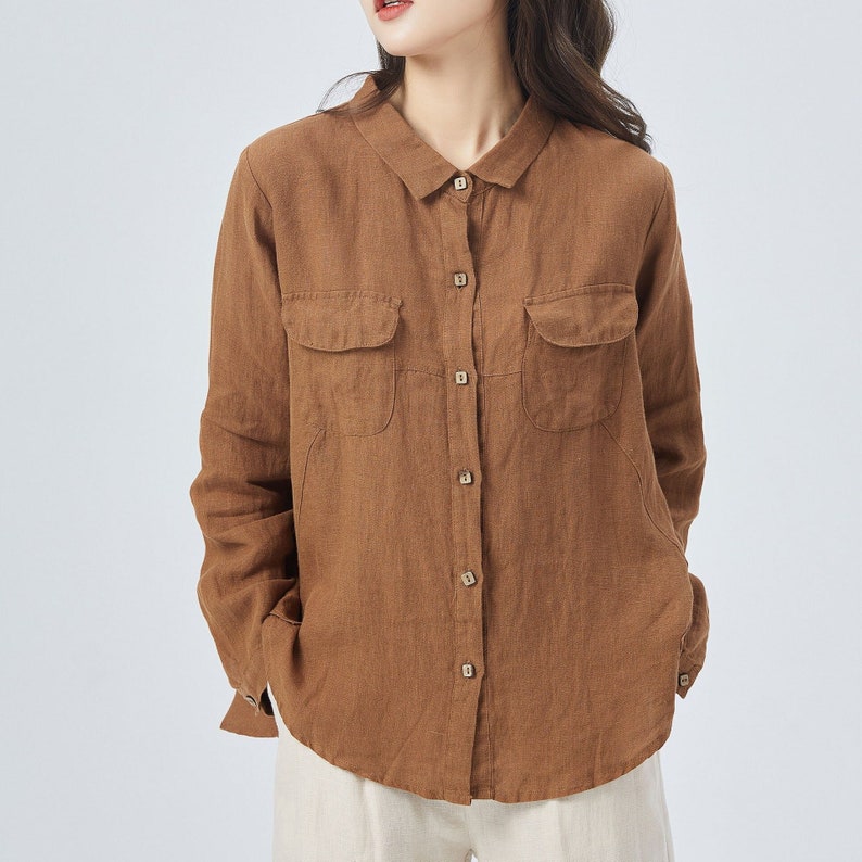 May include: A brown linen shirt with long sleeves, a button-down front, and two large patch pockets.