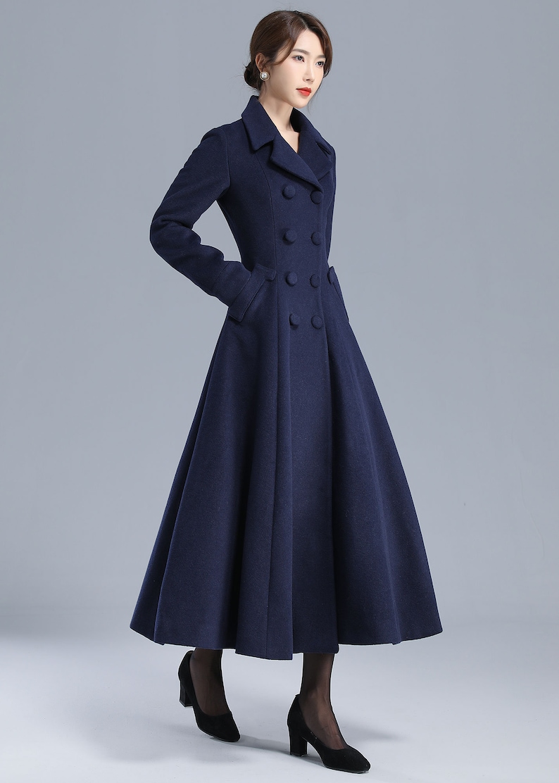 May include: A navy blue double-breasted coat with a flared skirt. The coat has a classic collar and large buttons.