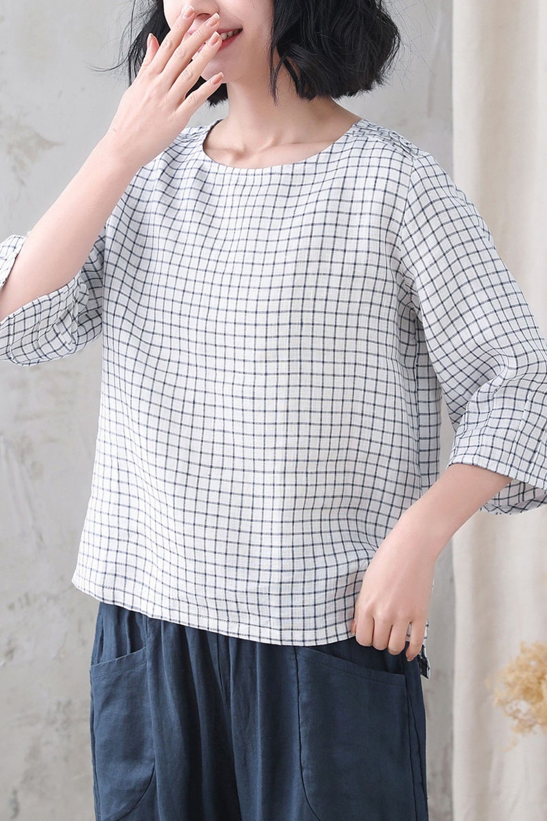 Op de afbeelding: Een wit en blauw geruit blouse met 3/4 mouwen. De blouse heeft een ronde hals en is gemaakt van een lichtgewicht stof.