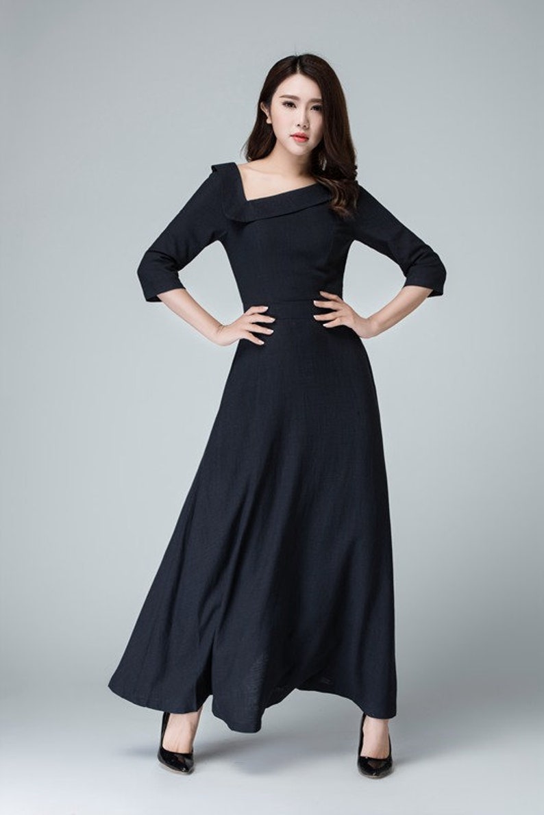 May include: A black maxi dress with a square neckline and three-quarter sleeves. The dress has a fitted bodice and a flowing skirt.