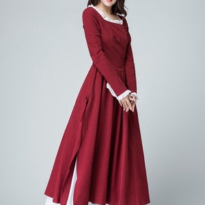 May include: A long, red dress with white lace trim at the neckline and cuffs. The dress has a square neckline and long sleeves. The skirt is full and flowing. The dress is made of a lightweight fabric and is perfect for a summer day.