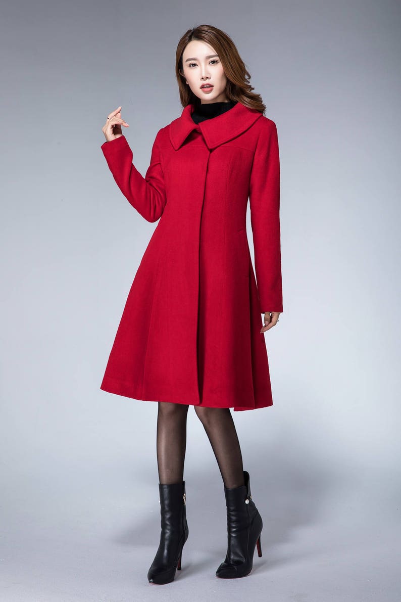 May include: A red wool coat with a wide collar and a flared skirt. The coat is knee-length and has a single button closure.