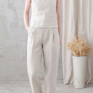 Pu&ograve; includere: Un top senza maniche in lino beige chiaro e pantaloni in lino abbinati. I pantaloni hanno una gamba larga e una vestibilit&agrave; rilassata.