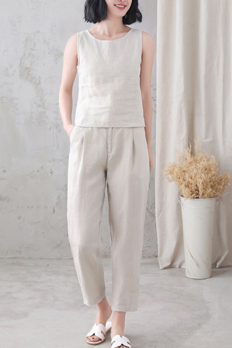 Pu&ograve; includere: Un top senza maniche in lino beige chiaro e pantaloni in lino abbinati. I pantaloni hanno una gamba larga e una vestibilit&agrave; rilassata.