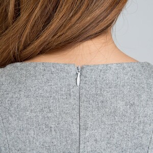 May include: Back view of a gray dress with a zipper closure.