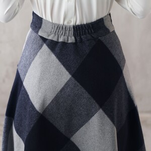 May include: A gray and navy blue plaid skirt with an elastic waistband.