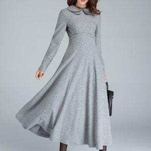 Puede incluir: Un vestido gris de manga larga con cuello de Peter Pan y falda acampanada. El vestido est&aacute; hecho de una tela suave y texturizada.