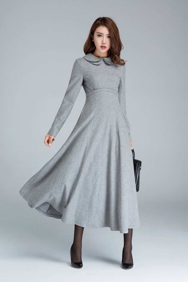 Puede incluir: Un vestido gris de manga larga con cuello de Peter Pan y falda acampanada. El vestido est&aacute; hecho de una tela suave y texturizada.
