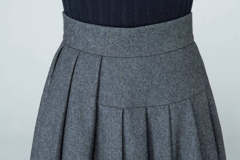 May include: A gray pleated skirt with a high waist.