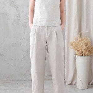 Pu&ograve; includere: Un top senza maniche in lino beige chiaro e pantaloni in lino abbinati. I pantaloni hanno una gamba dritta e una vestibilit&agrave; rilassata.