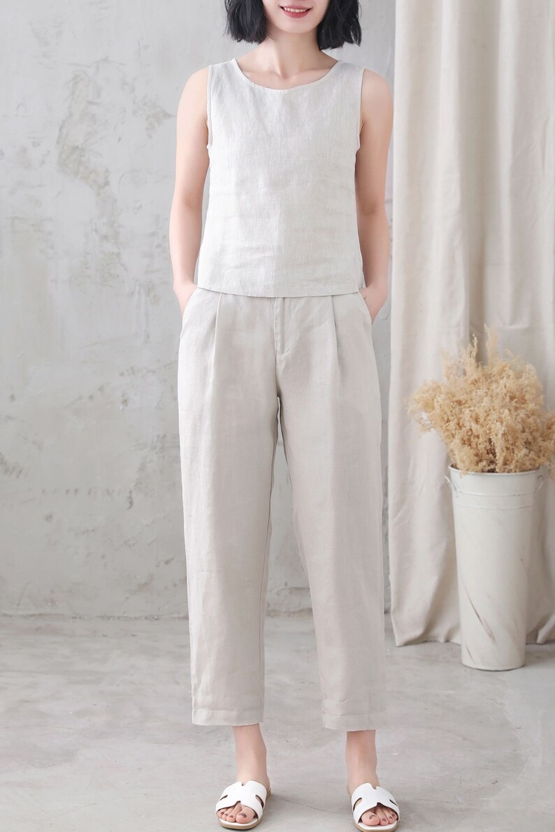 Pu&ograve; includere: Un top senza maniche in lino beige chiaro e pantaloni in lino abbinati. I pantaloni hanno una gamba dritta e una vestibilit&agrave; rilassata.