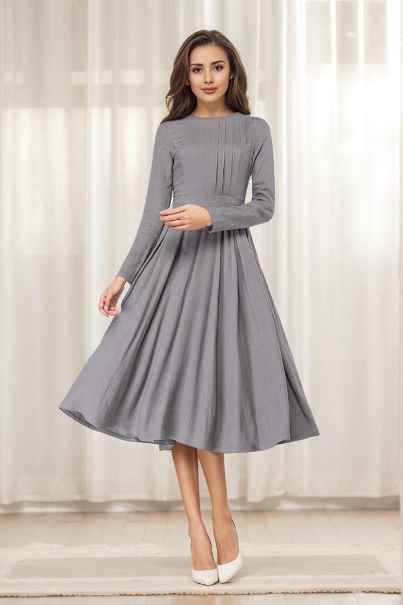 May include: A gray midi dress with long sleeves and a pleated skirt.