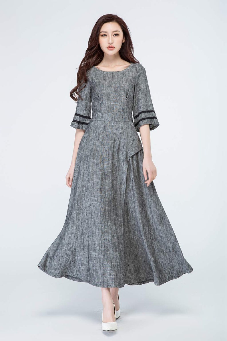 May include: A gray linen dress with black trim on the sleeves. The dress has a scoop neckline and a flowy skirt.