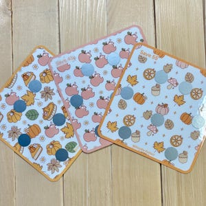 Può includere: Tre carte quadrate a tema autunnale. Ogni carta ha uno sfondo bianco con bordi arancioni ed è decorata con zucche, foglie e mele. Le carte hanno il testo "Save 45" e "Save 55".