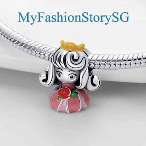 May include: A silver charm featuring a cartoon princess with a yellow crown, pink dress, and a red rose. The charm is on a silver chain.