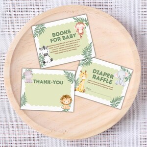 May include: Three baby shower cards featuring jungle animal illustrations. The cards are light green with scalloped edges and tropical leaf accents. Text on the cards reads "Books for Baby", "Thank-You", and "Diaper Raffle".