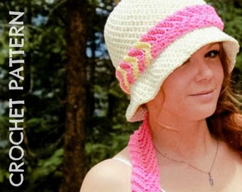 May include: A white crochet hat with a pink and yellow braided trim. The hat is worn by a person with long brown hair.