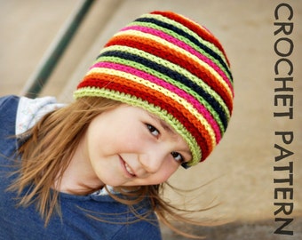 Può includere: Un bambino indossa un cappello a righe colorate all'uncinetto. Il cappello ha strisce alternate di rosso, arancione, giallo, verde, rosa, nero e verde chiaro. Il cappello è lavorato all'uncinetto con punto basso.