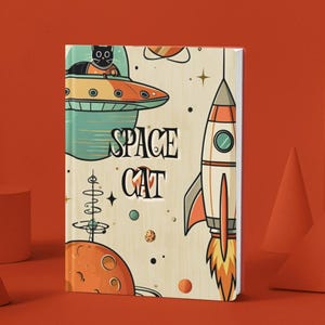 May include: A notebook with a retro space theme. The cover features a black cat in a spaceship, a rocket, planets, and the words "SPACE CAT". The color palette includes orange, teal, and cream.