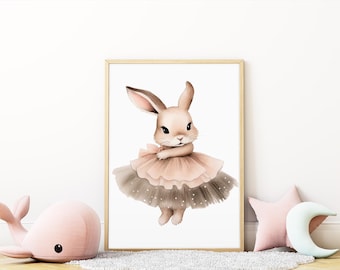 May include: Watercolor illustration of a bunny wearing a pink and gray tutu. The framed artwork features a light brown bunny with long ears and a bow. The image is displayed in a room with a pink whale and star-shaped pillow.