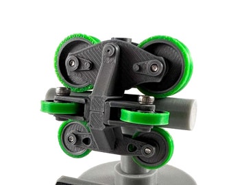 May include: A gray 3D printed model of a B&M wheel assembly with green wheels. The model is mounted on a gray base with the text "B&M WHEEL ASSEMBLY" printed on it.