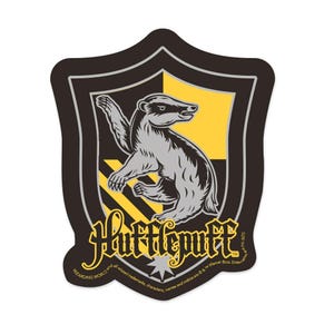 May include: A black and yellow Hogwarts house crest sticker featuring a badger with the text "Hufflepuff" and a copyright notice.