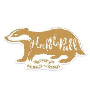 May include: A gold badger silhouette with the word "Hufflepuff" written in white across the body. The words "Dedication, Patience x Loyalty" are written below the badger.