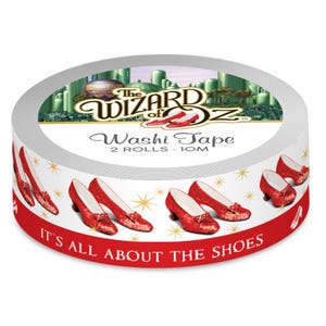 May include: A roll of white washi tape with a red and white design featuring ruby slippers from the Wizard of Oz. The tape has the text "The Wizard of Oz" and "Washi Tape 2 Rolls . 10M" on the label. The text "It's All About The Shoes" is printed on the bottom of the roll.