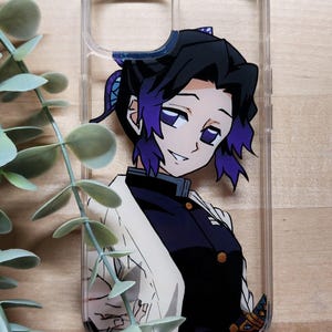 Op de afbeelding: Transparante telefoonhoes met een kleurrijke anime-personage. Het personage heeft zwart haar met paarse highlights en draagt een donker uniform en een witte jas. De hoes is versierd met een gedetailleerde illustratie.
