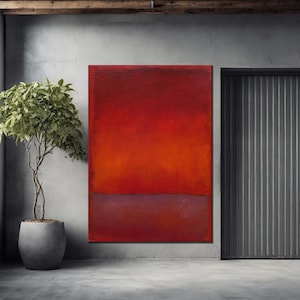 May include: Abstract red and orange painting with a dark red lower section. The artwork is displayed on a gray wall next to a potted plant and a metal door.