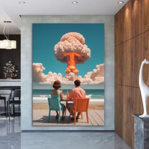 Könnte beinhalten: Leinwanddruck, der ein Paar an einem Strand zeigt, das einer Atompilzwolke gegenübersteht. Der Himmel ist blau, das Meer ist sichtbar. Das Paar sitzt an einem Tisch auf orangefarbenen und türkisfarbenen Stühlen. Surrealistische Kunst.