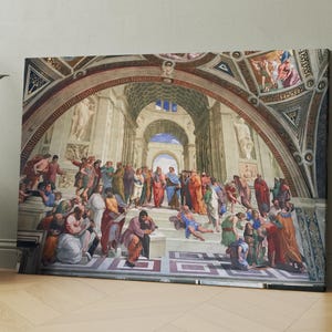 May include: A large canvas print of a Renaissance-style painting depicting a gathering of figures in an architectural setting. The artwork features a vibrant colour palette with reds, blues, and golds, and is leaning against a wall.