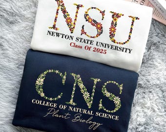 May include: Two white and navy blue sweatshirts with floral lettering. The white sweatshirt says "NSU NEWTON STATE UNIVERSITY Class of 2025". The navy blue sweatshirt says "CNS COLLEGE OF NATURAL SCIENCE Plant Biology".