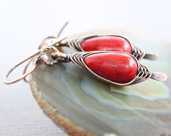 May include: A pair of copper wire wrapped earrings with red gemstone drops. The earrings have a simple wire hook fastening.