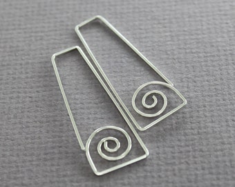 May include: A pair of silver earrings with a spiral design. The earrings are made of thin wire and have a simple, modern look.