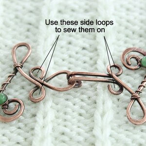 May include: Copper wire toggle clasp with two green gemstone accents. The clasp has two side loops for sewing onto fabric. "Use these side loops to sew them on" is written above the clasp.