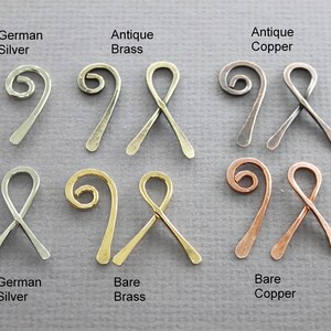 May include: Six pairs of wire ribbon ends in different finishes: antique brass, antique copper, bare brass, bare copper, and German silver. Each pair features a twisted wire loop and a straight wire end.