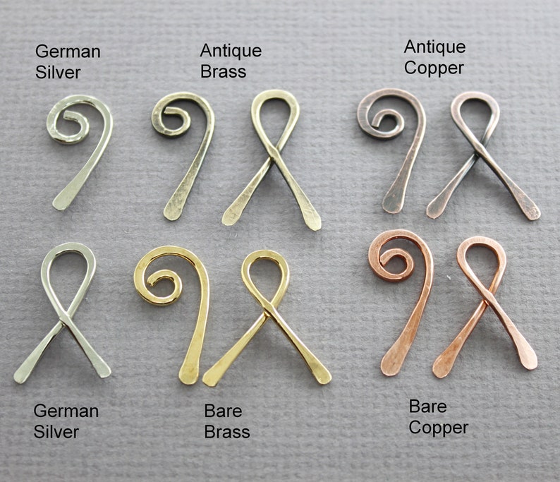 May include: Six pairs of wire ribbon ends in different finishes: antique brass, antique copper, bare brass, bare copper, and German silver. Each pair features a twisted wire loop and a straight wire end.